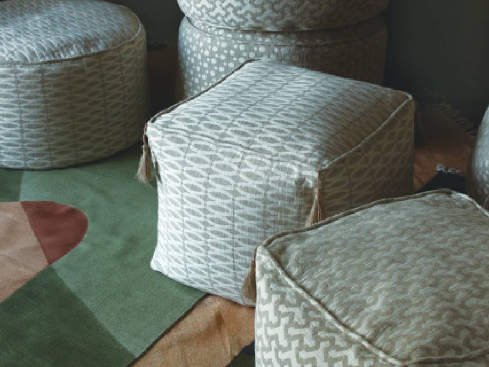 グレーのアデペシュフレンチリネンビーズクッションがリビングルームに配置されており、リネンとコットンのカバーと発泡ビーズの中材が特徴的なモダンなデザイン。