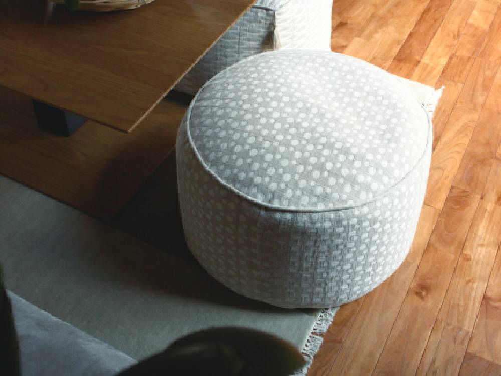 アデペシュのグレー色フレンチリネンビーズクッションがリビングルームのソファに配置されている様子