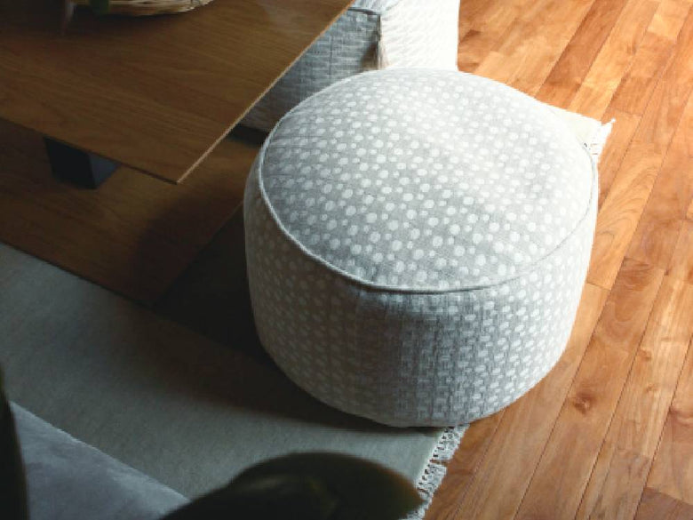 アデペシュのグレー色フレンチリネンビーズクッションがリビングルームのソファに配置されている様子