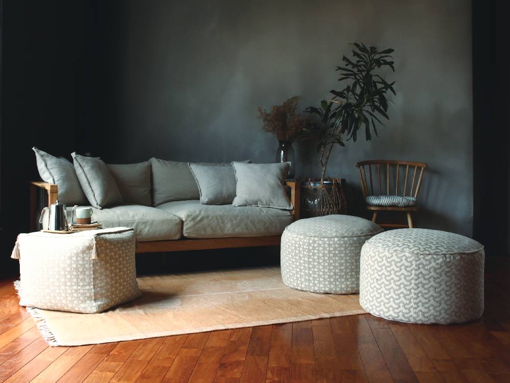 リビングルームのソファに置かれたグレーのリネンクッションとクッションカバー