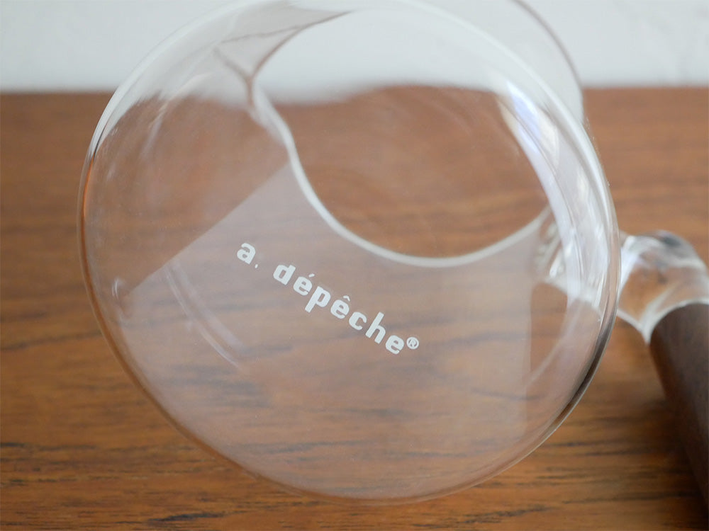 アデペシュのnoonコレクションに属するガラスとウォールナット素材のティーポットとデザインカップのセット