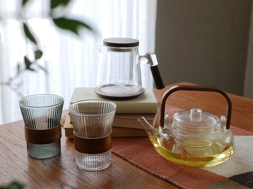アデペシュnoonコレクションのホウケイ酸ガラスとウォールナット製ティーポットとデザインカップが美しく並べられたセット