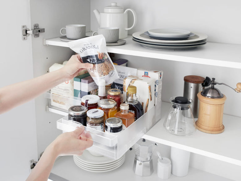 キッチンの冷蔵庫内に設置されたタワー型収納ケースで、カップや食器が整然と並ぶ棚