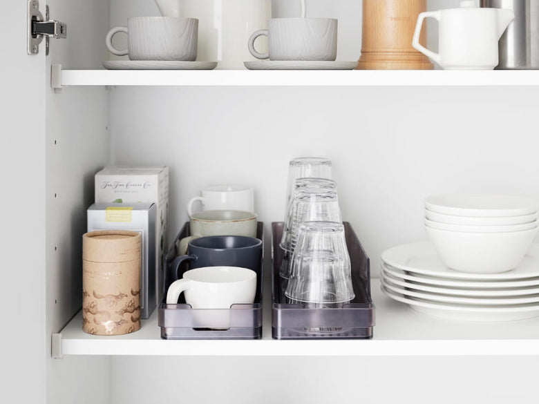 「tower / タワー」冷蔵庫中缶ストッカーがキッチンの棚に置かれ、食器やカップが整然と整理されています。