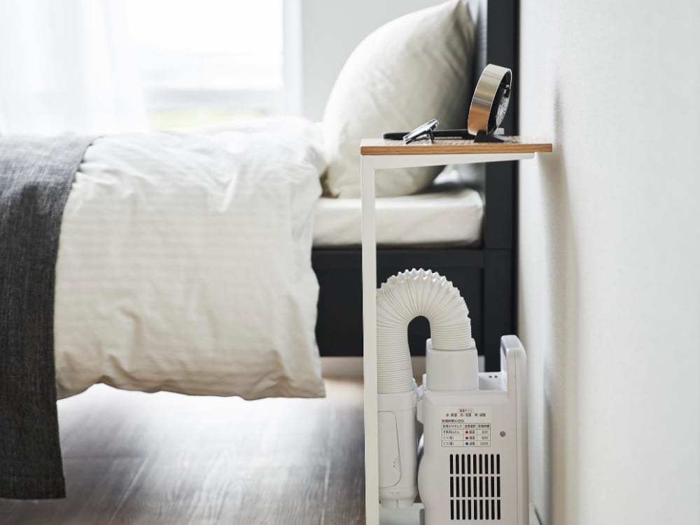 キャスター付き目隠し布団乾燥機スタンド「tower」の全体写真。スチール製の天板と天然木化粧繊維板を使用し、移動可能なキャスターが付いています。