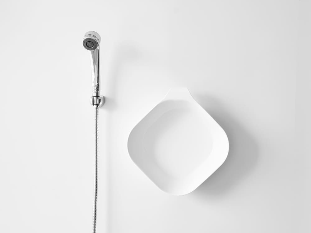 銀色のマグネット＆引っ掛け湯おけが浴室の配管金具に取り付けられている様子