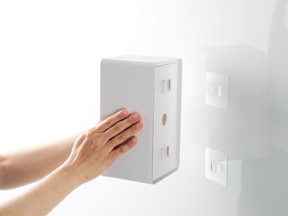 電気コンセントに取り付けられたTowerフィルムフッククレンジングタオルケース