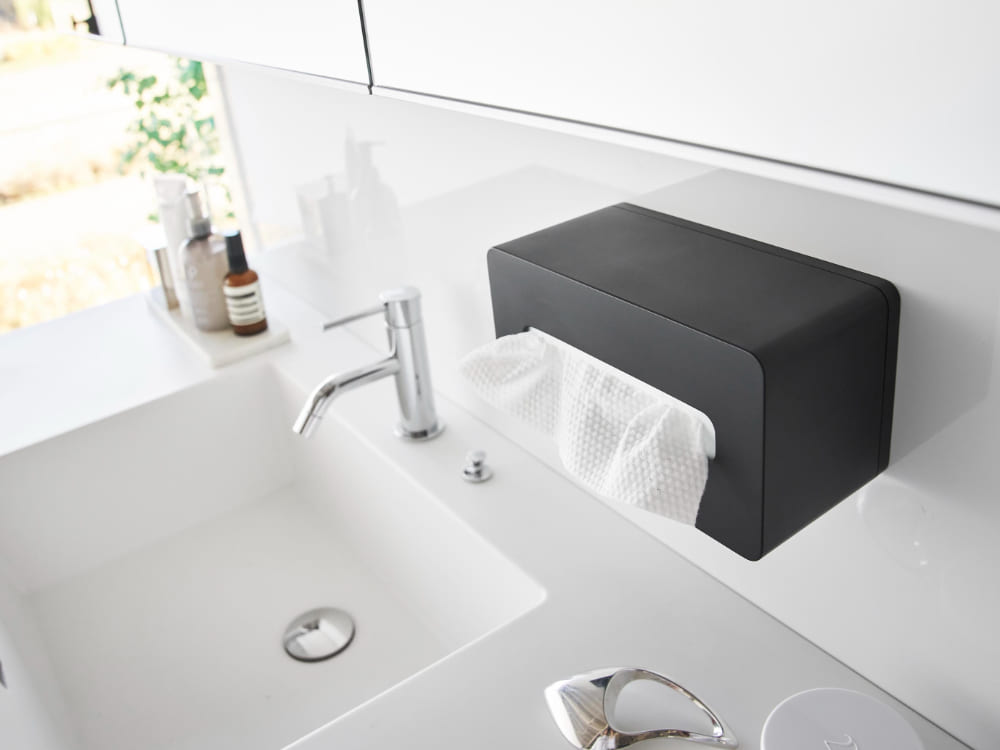 銀色のバスルームに設置されたシンクと水栓、陶器製の浴室キャビネットやハンドドライヤーが映った画像