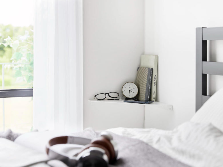 ベッドルームの壁に設置された【tower / タワー】石こうボード対応ウォールコーナーシェルフとベッドが調和したインテリア