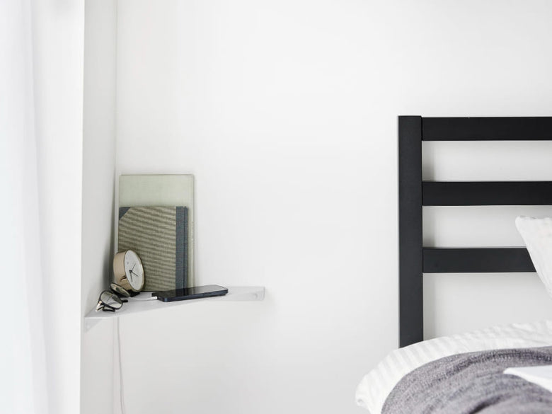 ベッドルームの壁に取り付けられた【tower / タワー】石こうボード対応ウォールコーナーシェルフと整った寝具インテリア