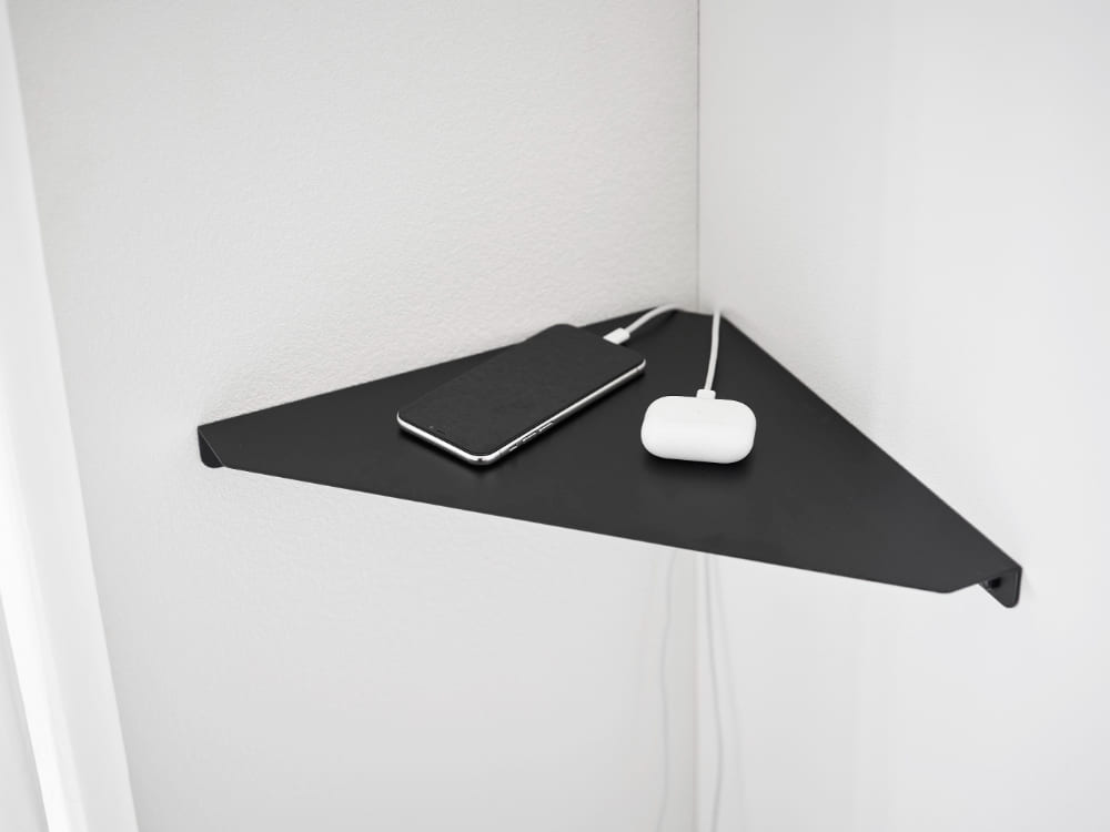 スチール製「tower / タワー」ウォールコーナーシェルフが石こうボードの壁に設置されている様子