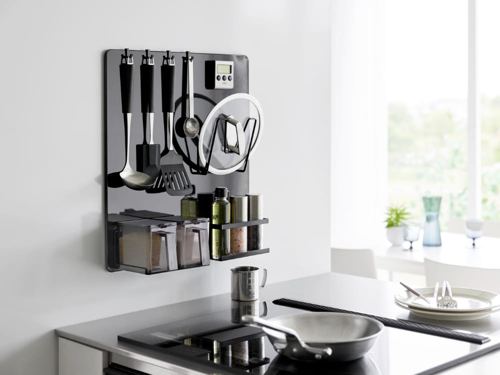 タワーフィルムフックスチールパネルに調理器具や食器が掛けられたキッチンの様子