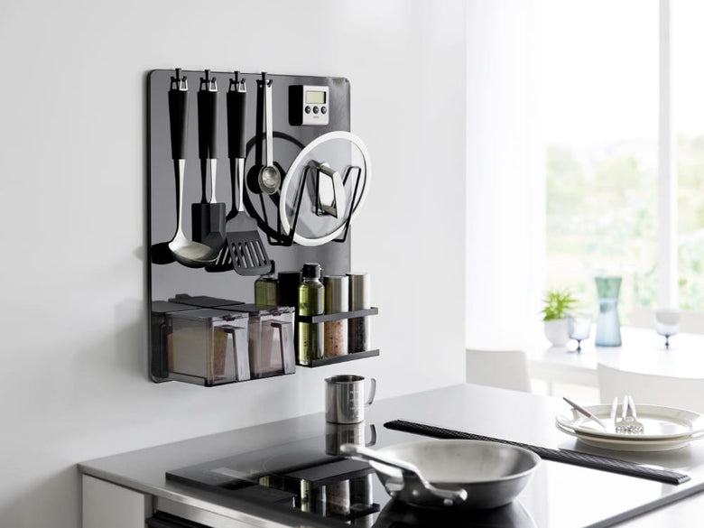 タワーフィルムフックスチールパネルに調理器具や食器が掛けられたキッチンの様子