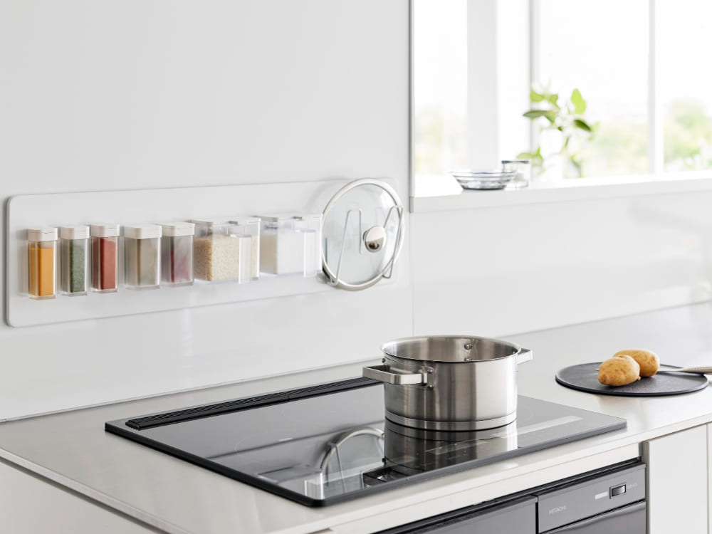 キッチンカウンターに設置されたタワー フィルムフックスチールパネルで、調理器具や家庭用ハードウェアが整然と掛けられている様子