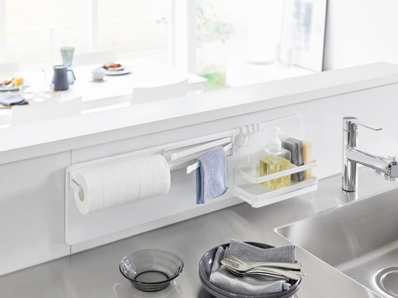 キッチンシンクに取り付けられたタワーフィルムフックスチールパネルと蛇口、ボトルがカウンタートップに配置されている様子