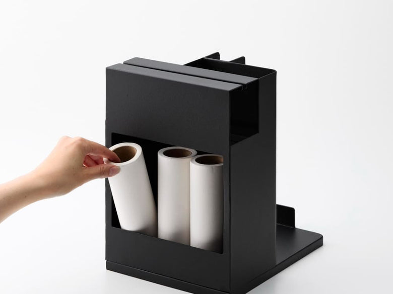 スチール製の「タワー」スティッククリーナー＆ツールオーガナイザーが棚に配置され、各収納スペースに掃除用具が整然と収納されている様子