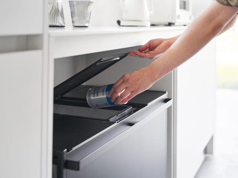 キッチンの棚に銀色の蓋付きタワーダストワゴンが設置されている様子