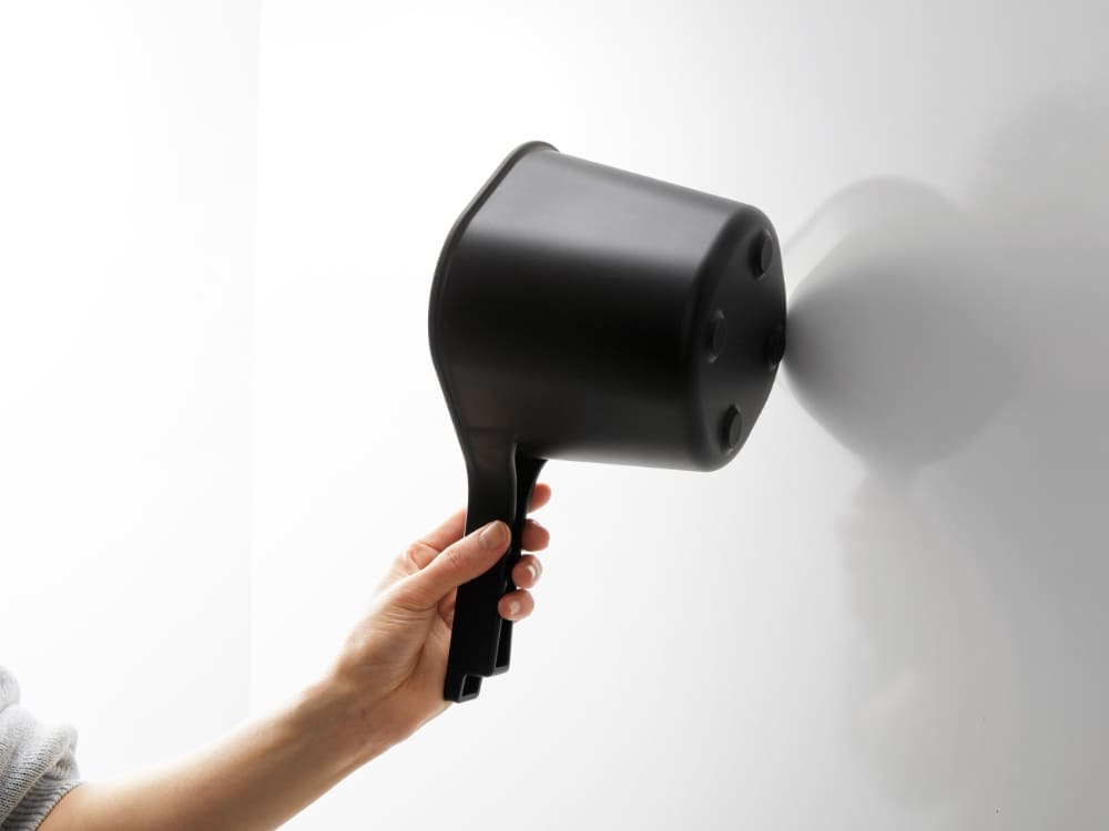 プラスチック製のヘアドライヤーや電子機器がタワーマグネット手おけに掛けられている様子