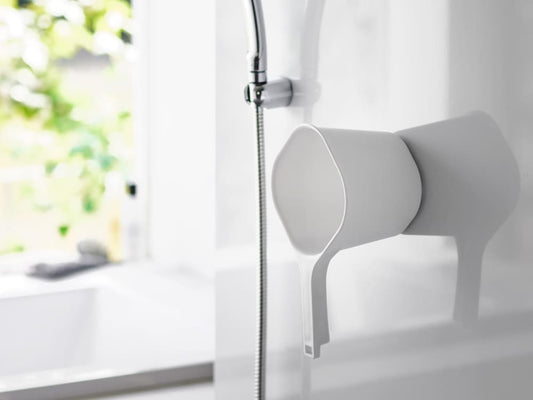 浴室の壁にマグネットで固定された【tower】マグネット手おけ。タップや配管設備と共に設置され、家庭用ハードウェアとして安全に収納可能