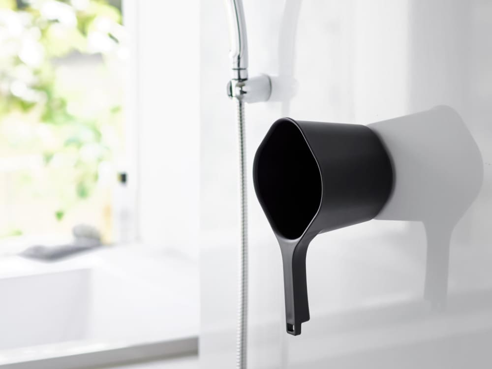 タワーシリーズの銀色マグネット手おけが平らなスチール壁面にデザインされた形で取り付けられている様子