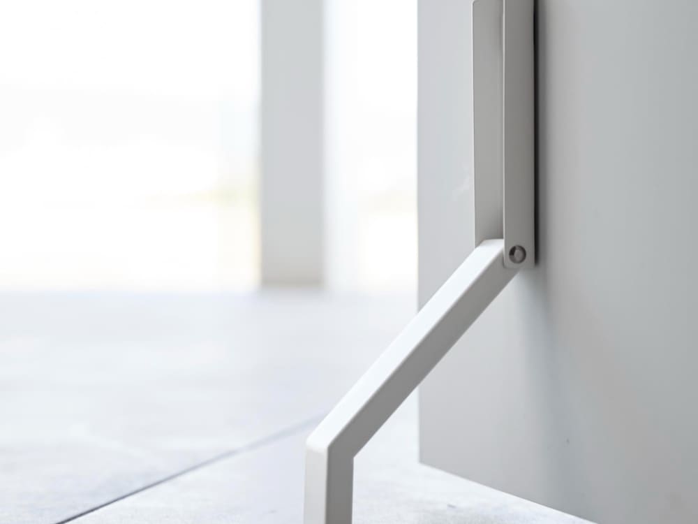 グレーの金属製プランク床に置かれたタワーマグネット折り畳みドアストッパー