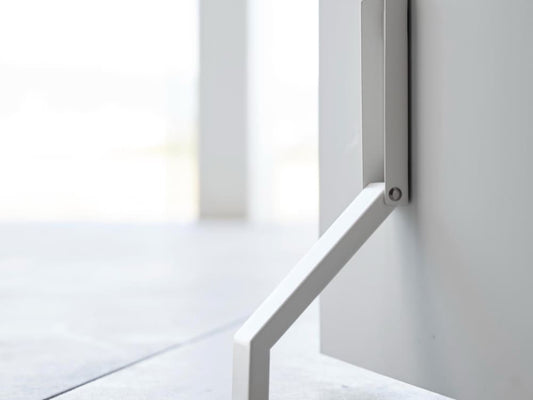 グレーの金属製プランク床に置かれたタワーマグネット折り畳みドアストッパー