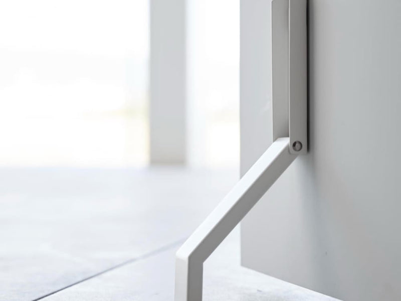 グレーの金属製プランク床に置かれたタワーマグネット折り畳みドアストッパー