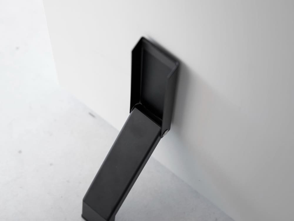 玄関ドアに取り付けられた灰色のスチール製マグネット折り畳みドアストッパー【tower】