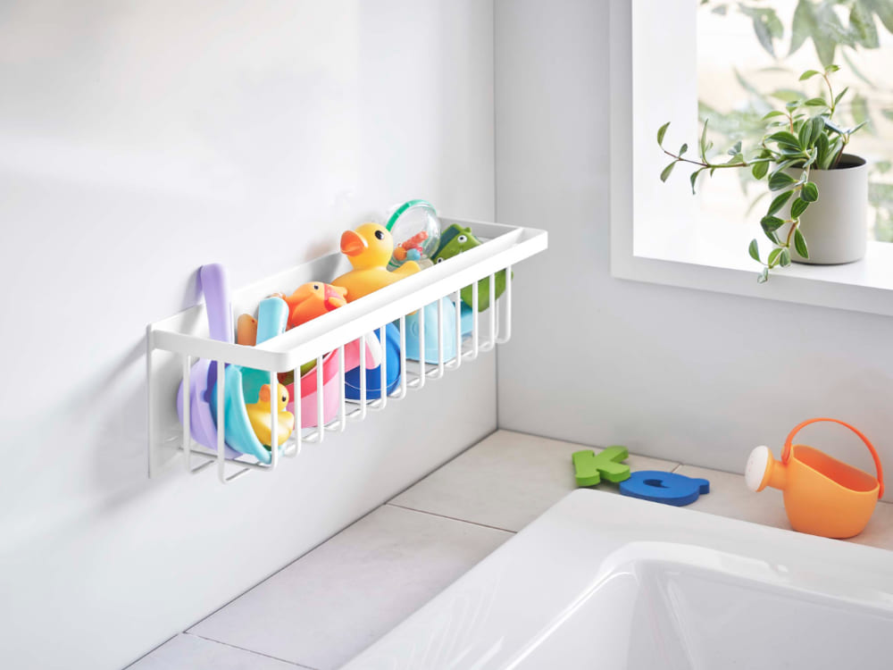 スチール製マグネットバスルームバスケットが浴室の棚に取り付けられ、歯ブラシホルダーやバス用品が整然と収納されている様子