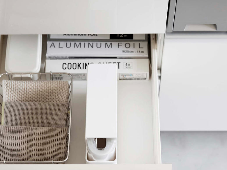 キッチンキャビネット内に設置されたスリムプラスチックバッグケース【タワー】。グレーとシルバーのABS樹脂製で、引き出しやカウンタートップと調和するモダンなデザイン。