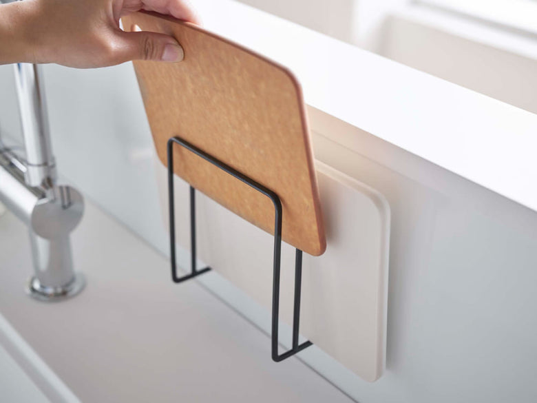 スチール製のタワーマグネットまな板スタンドに複数のまな板が積み重ねられ、キッチンの平らな金属壁面に固定されている様子