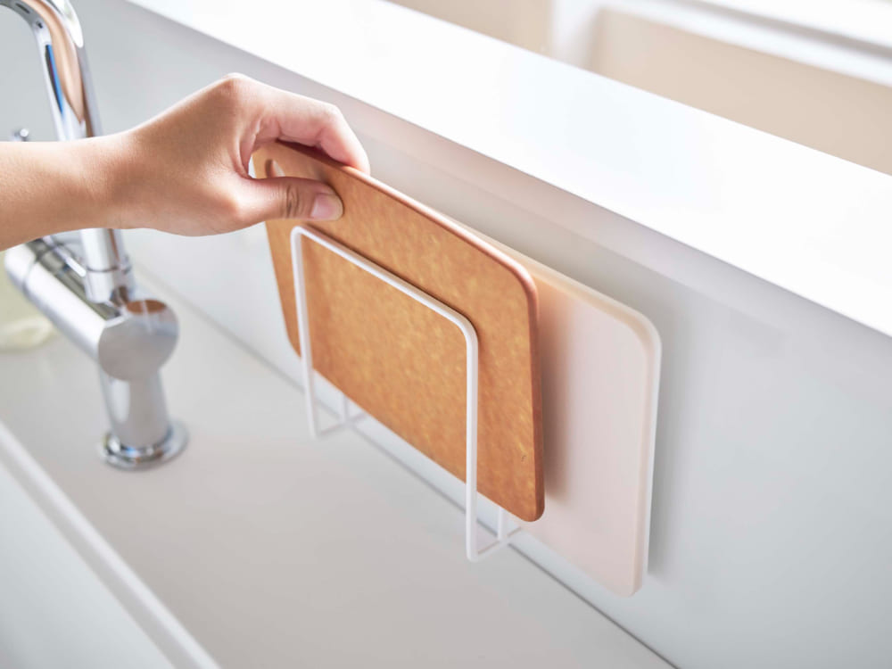 キッチンのシンク横に配置されたマグネットまな板スタンドと木製まな板