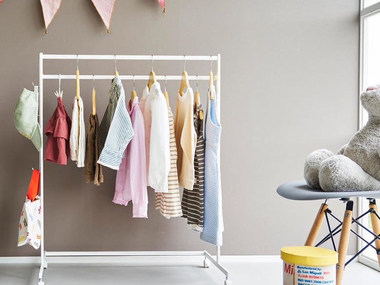 ピンク色の【tower / タワー】収納力アップハンガーラックに衣類が掛けられたデザイン