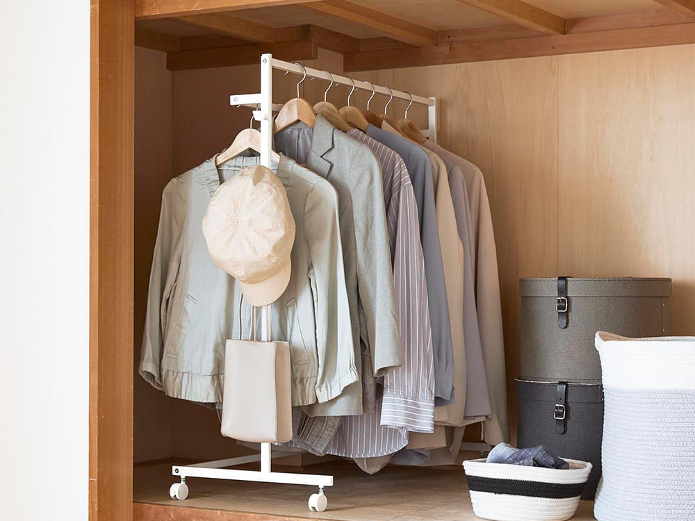 タワー型収納力アップハンガーラックが木製シェルフやクローゼットとともに整理された室内のインテリア