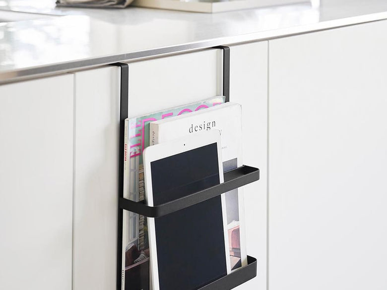 キッチンのキャビネットに設置されたアルミ製タワー型引っ掛け宿題＆タブレットPCラック。ガラス棚と観葉植物が配置されています。