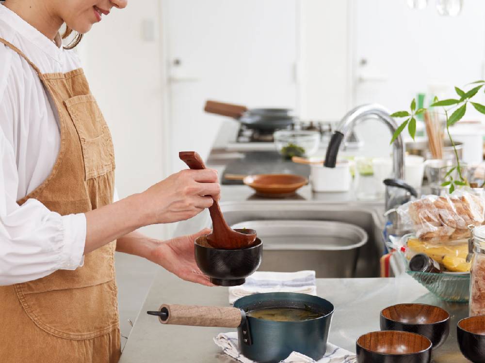 藤田金属の「今日を元気にするお味噌汁パン」とキッチン用品が調理中にキッチン上に配置されている様子