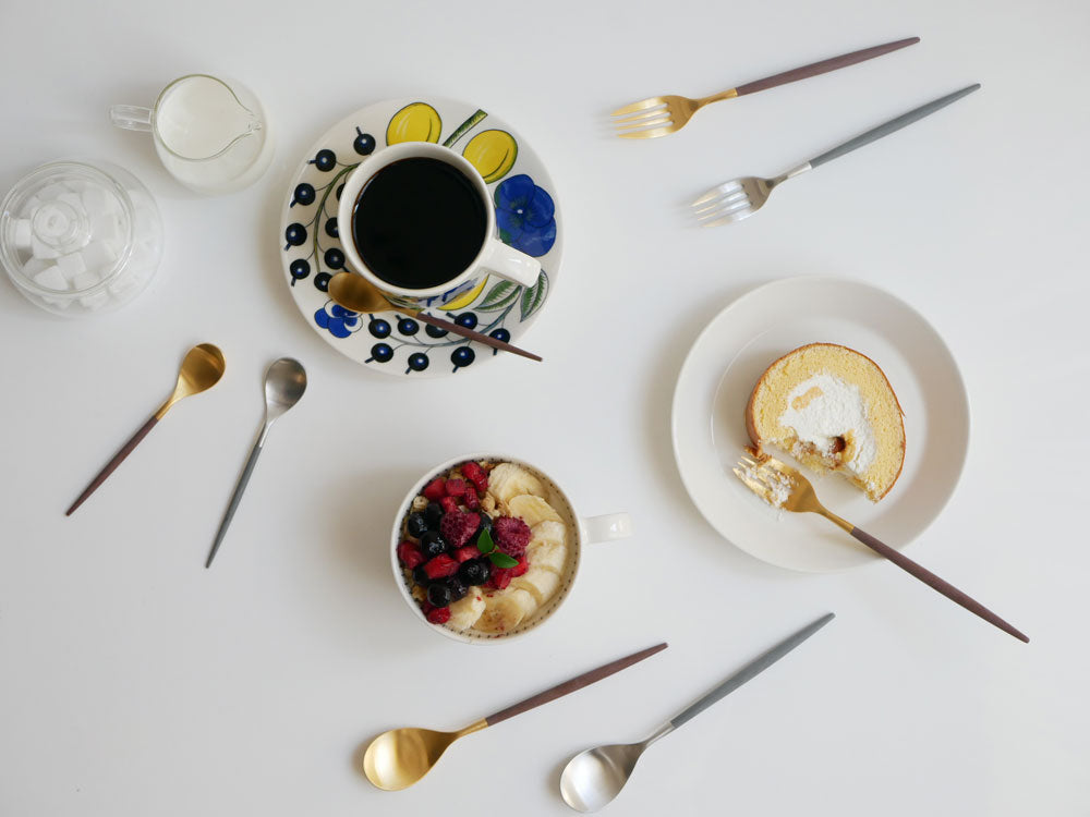 ブラウンゴールドとグレーシルバーの【Cutipol/クチポール】MIOカトラリーセットのフォークとスプーンが並んだ食卓用具