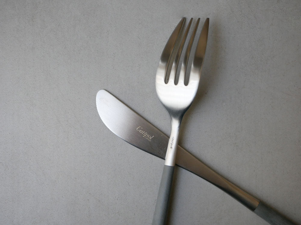 クチポールのMIOカトラリーセット。ブラウンゴールドとグレーシルバーのフォーク、スプーン、ナイフが整然と並んだ食卓用具の写真
