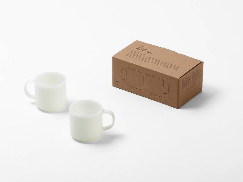 ホウケイ酸ガラス製のミルクガラスマグカップが2個テーブルに並べられています