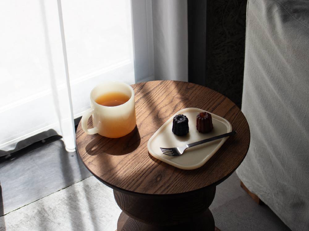 木製テーブルに並べられた白色と翡翠色のミルクガラスマグカップ2個セット