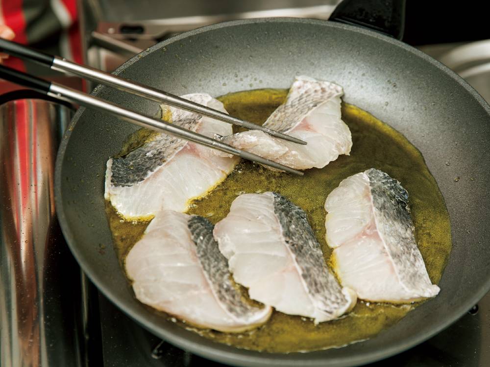 セレクト100のステンレス菜箸を使って魚介料理を調理している様子