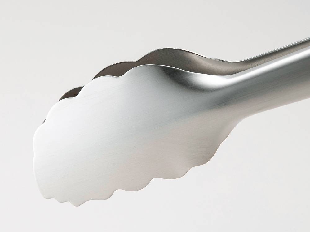 セレクト100の24cmトングがクリームやスプーンなどの食器と一緒にキッチンで使用されている様子