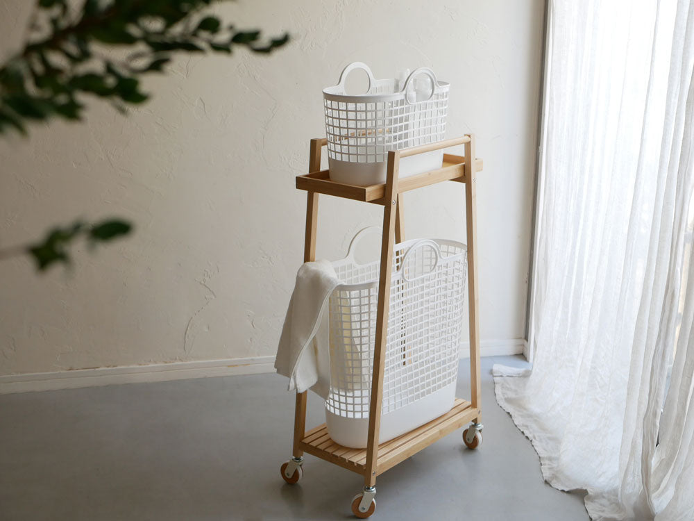 竹製バンブーランドリーワゴンとプラスチックバスケットが室内で整理整頓されている様子