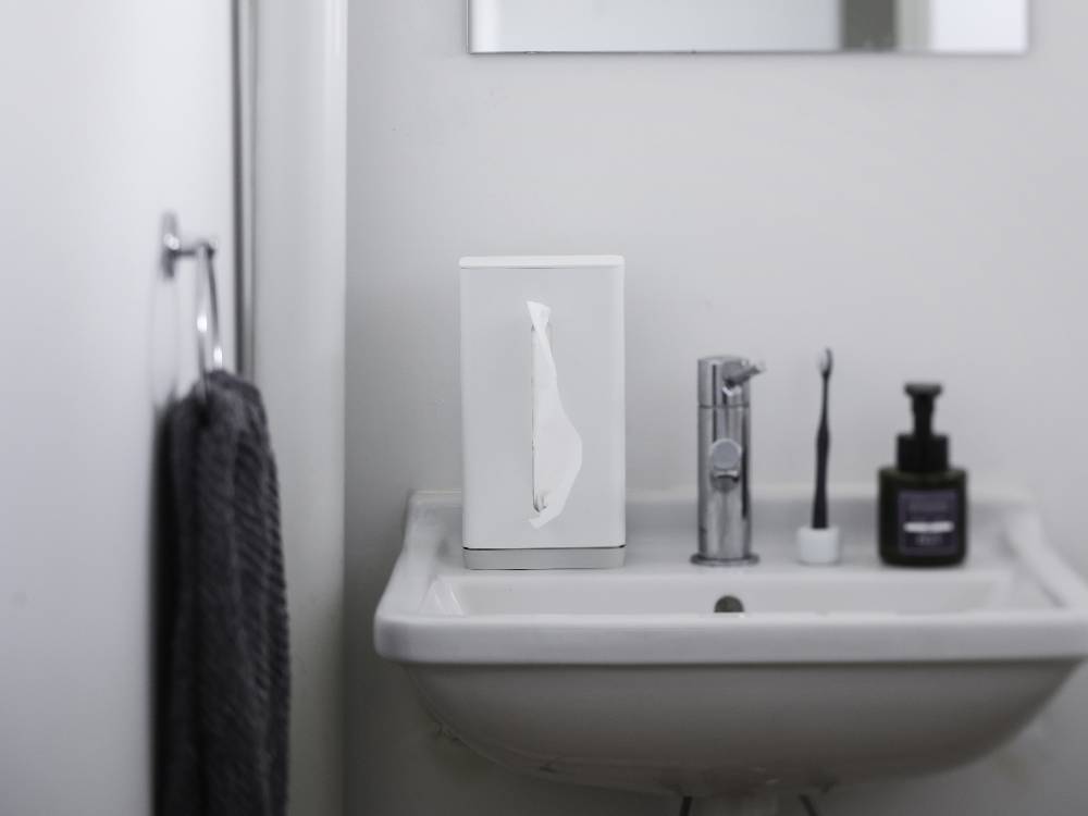 洗面台に取り付けられたシルバーのマーナティッシュケース