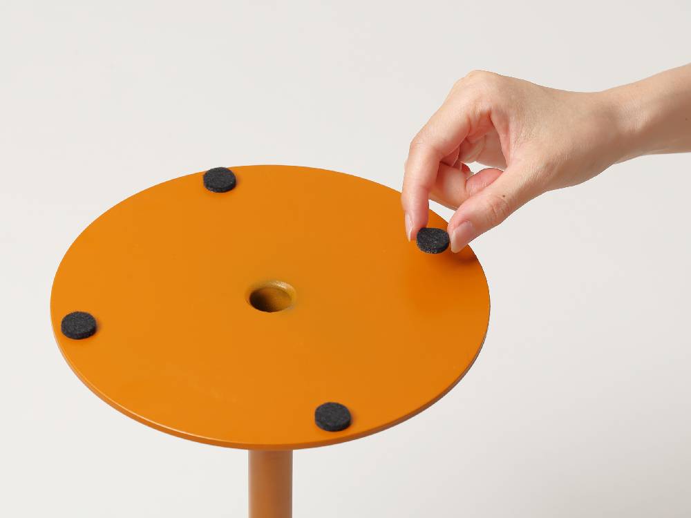オレンジ色のプラスチック製スツールが配置された【ideaco/イデアコ】スチールファニュチャー サイドテーブル23の画像
