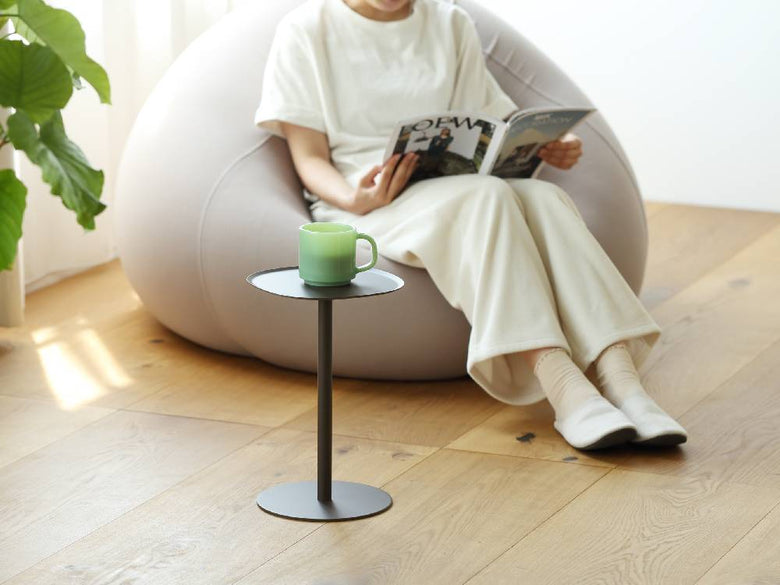 リビングルームに配置されたイデアコのスチールサイドテーブル23、木製フローリングと椅子、ハウスプランツが調和したインテリア