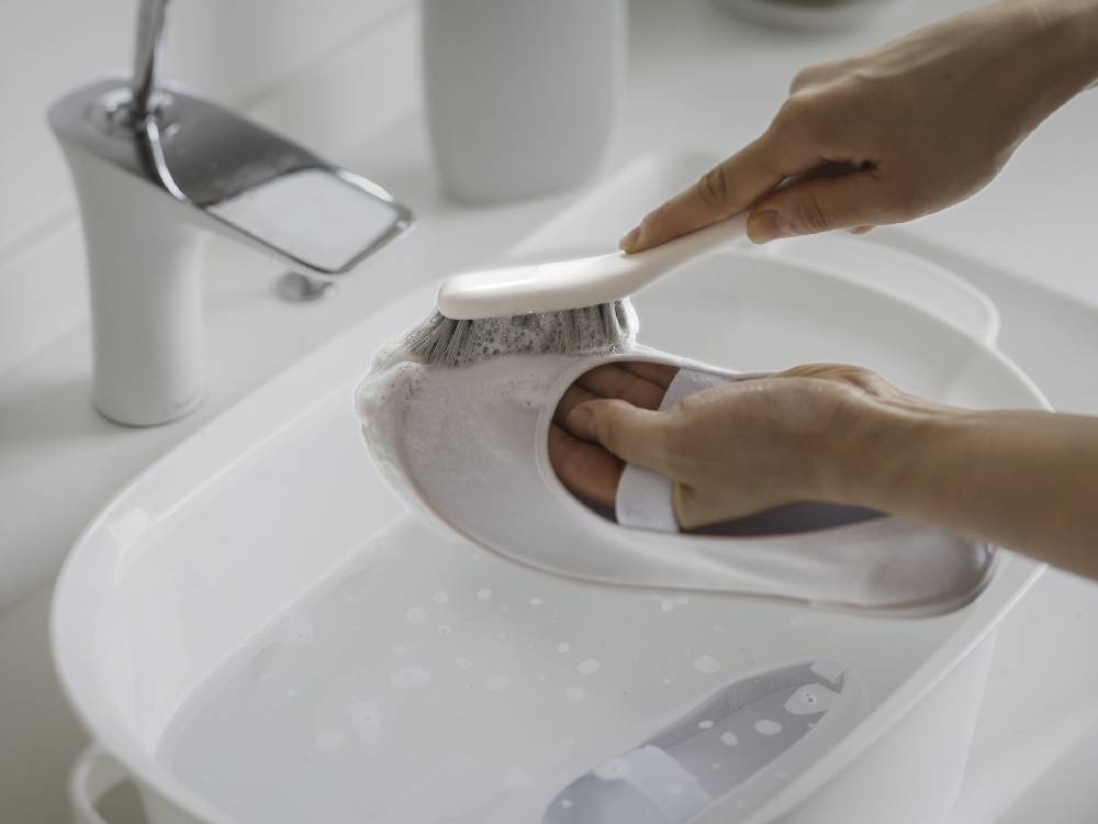 marna（マーナ）の白と銀色のシューズブラシ。ポリプロピレン製の柄とポリブチレンテレフタレート製の毛を使用し、コンパクトで軽量なデザイン。靴のお手入れに最適なブラシ