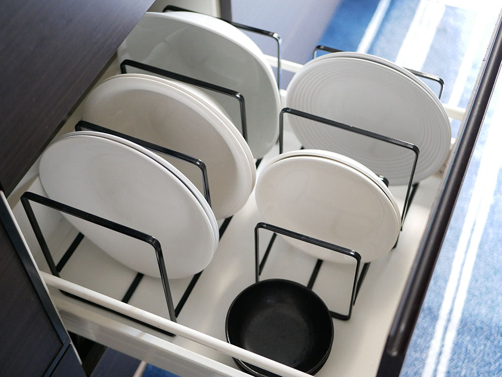 タワー製スチールディッシュラックに食器やカトラリーが整然と配置されたキッチンの様子