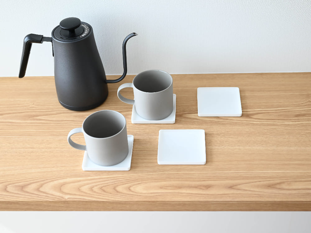 シリコーン製のタワー立体コースターが角型と丸型でテーブル上に並べられている様子