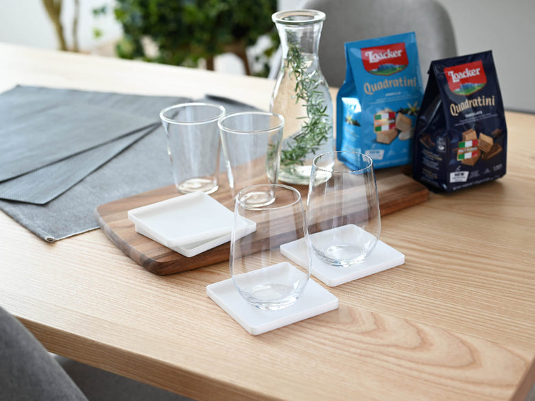 シリコーン製の角型と丸型の立体コースターがテーブル上に並べられている